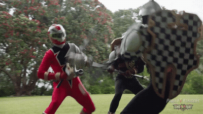 Two Power Rangers Fighting With Swords and Shields