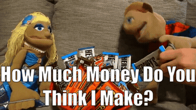 Two Puppets Are Sitting Next To A Pile Of Hershey 'S Bars GIF