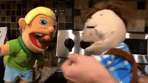 Two Puppets Standing Next To Each Other In Kitchen GIF