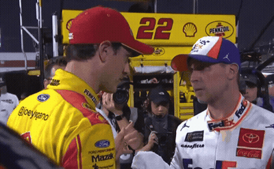 Two Race Car Drivers Are Shaking Hands In Front Of A Pennzoil Sign GIF