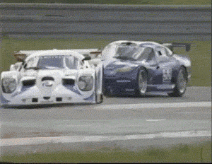 Two Race Cars Are Racing On A Track And One Has The Number 26 On The Side GIF