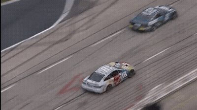 Two Race Cars Racing On Track With Large Logo GIF