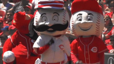 Two Reds Mascots Are Standing Next To Each Other In A Crowd GIF