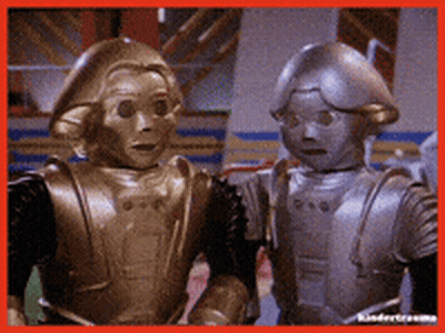 Two Robots Are Standing Next To Each Other And Looking At The Camera GIF
