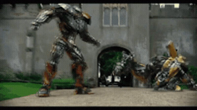 Two Robots Standing In Front Of Building GIF