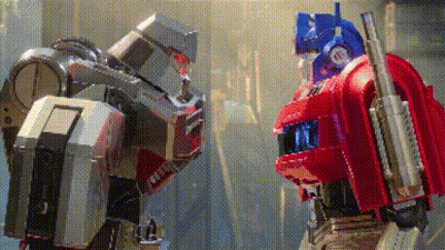 Two Robots Standing Next To Each Other One Is A Transformer GIF