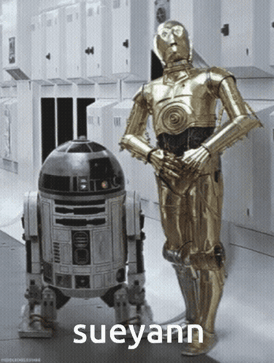 Two Robots Standing Next To Each Other GIF