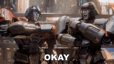 Two Robots Standing Together Saying Okay GIF