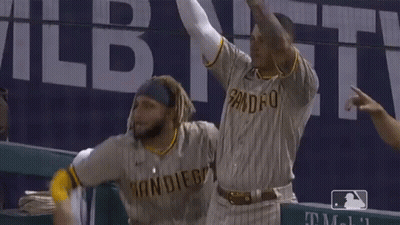 Two San Diego Baseball Players Are Celebrating With Their Hands In The Air GIF