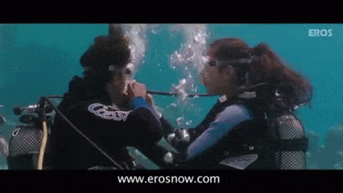 Two Scuba Divers Are Looking At Each Other In The Water And The Website Erosnow.com Is Visible In The Corner GIF