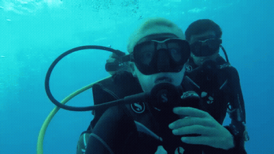 Two Scuba Divers Are Taking A Selfie In The Water GIF