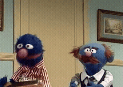 Two Sesame Street Characters Standing In Room GIF