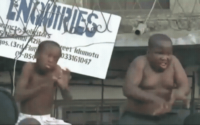 Two Shirtless Boys Dancing In Front Of Enquiries Sign GIF