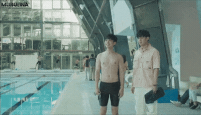 Two Shirtless Men Are Standing Next To A Swimming Pool GIF