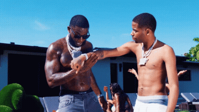 Two Shirtless Men Are Standing Next To Each Other And One Of Them Has A Tattoo On His Arm GIF
