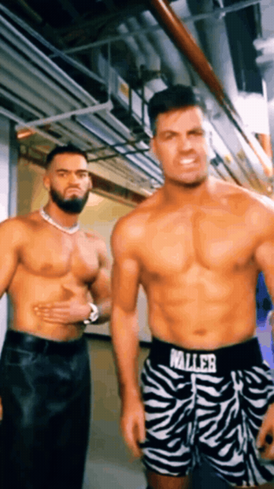 Two Shirtless Men Are Standing Next To Each Other In A Hallway Wearing Zebra Print Shorts That Say Waller GIF