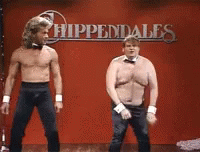 Two Shirtless Men Dancing In Front Of Hippendales Sign GIF
