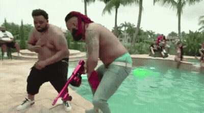 Two Shirtless Men Holding Pink Gun In Pool GIF
