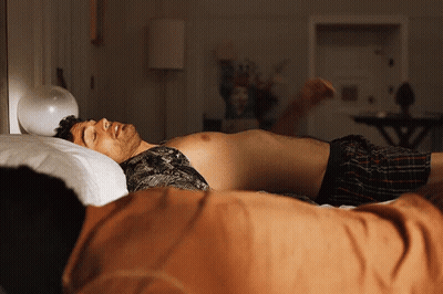 Two Shirtless Men Lying On Bed GIF
