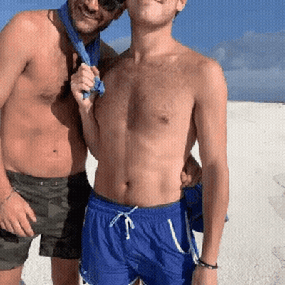 Two Shirtless Men On Beach One Holding Towel GIF