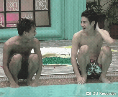 Two Shirtless Men Squatting By Pool GIF