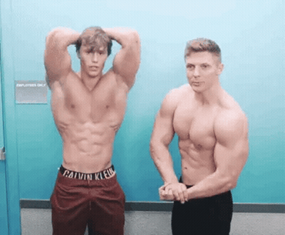 Two Shirtless Men Standing Next To Door GIF