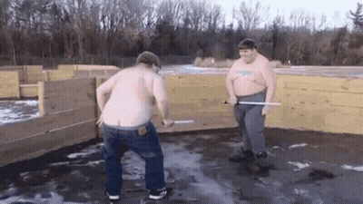 Two Shirtless Men With Swords At Wooden Fence GIF