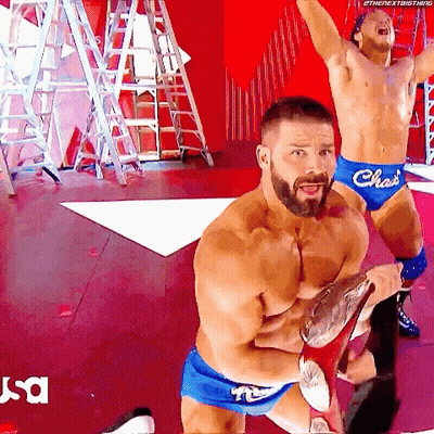 Two Shirtless Wrestlers In Blue Shorts With The Word Chas On Them GIF