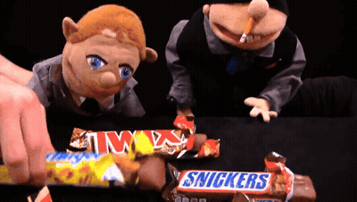 Two Snickers Candy Bars Are Being Eaten By Two Puppets GIF