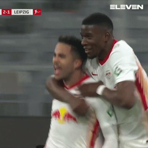 Two Soccer Players Are Celebrating A Goal Against Leipzig In A Stadium GIF