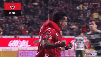 Two Soccer Players Are Celebrating A Goal In Front Of A Crowd GIF