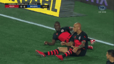 Two Soccer Players Are Celebrating A Goal In Front Of A Sign That Says Fox Sports GIF