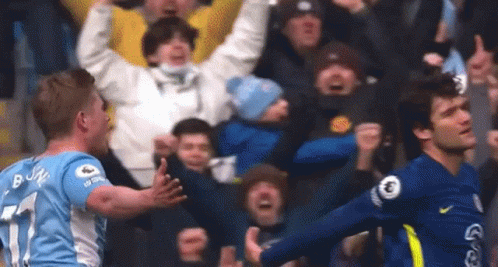 Two Soccer Players Are Celebrating A Goal In Front Of The Crowd . GIF