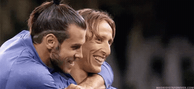 Two Soccer Players Are Hugging Each Other And Smiling . GIF