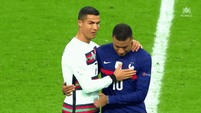 Two Soccer Players Are Hugging Each Other On A Field . GIF