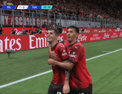 Two Soccer Players Are Hugging Each Other On A Field With An Emirates Advertisement Behind Them GIF