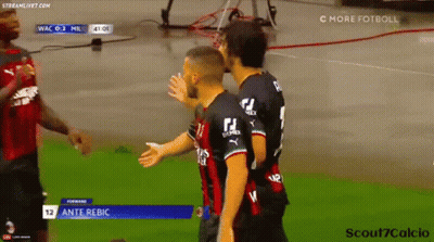 Two Soccer Players Are Hugging Each Other On The Field . GIF