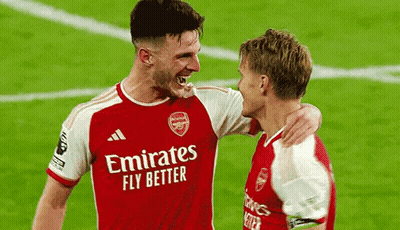 Two Soccer Players Are Hugging Each Other On The Field . GIF