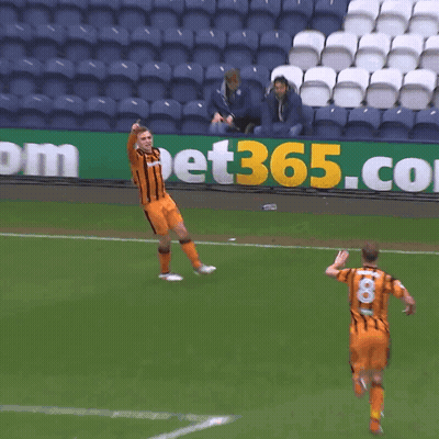 Two Soccer Players Are Running On A Field In Front Of A Sign That Says Bet365 GIF