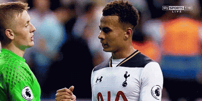 Two Soccer Players Are Shaking Hands On A Field During A Game . GIF
