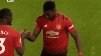 Two Soccer Players Are Shaking Hands On The Field During A Match . GIF