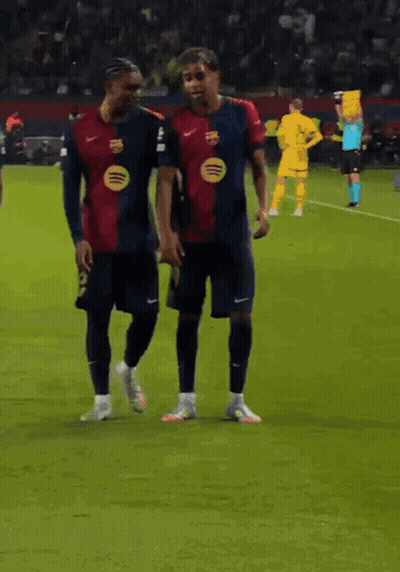 Two Soccer Players Are Walking On The Field And One Has A Spotify Logo On His Jersey GIF