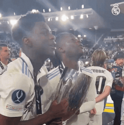 Two Soccer Players Holding Trophy With Number 0 GIF