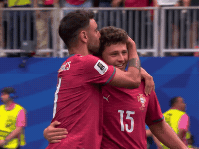 Two Soccer Players Hugging Each Other With One Wearing The Number 15 GIF