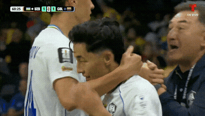 Two Soccer Players Hugging In Front Of 60:25 Scoreboard GIF
