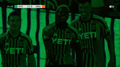 Two Soccer Players Hugging In Front Of Scoreboard Saying Hou GIF