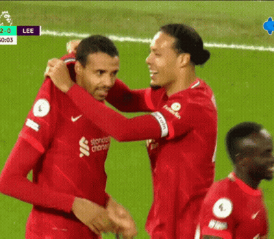 Two Soccer Players Hugging In Standard Charter Jerseys GIF