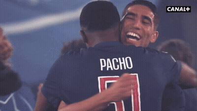 Two Soccer Players Hugging With The Name Pacho On The Back Of Their Shirt GIF