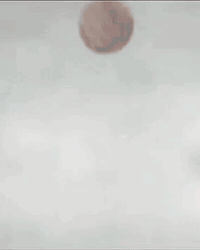 Two Soccer Players In Red Jerseys And Blue Shorts Kick A Ball GIF