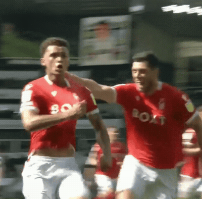 Two Soccer Players In Red Jerseys That Say Boat On Them GIF